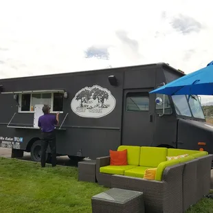 a black food truck parked in a parking lot