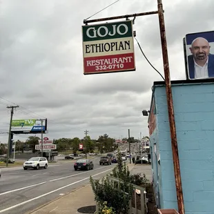 a sign for a restaurant on the corner of a street