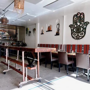 a restaurant with tables and chairs and a hamsa hand on the wall
