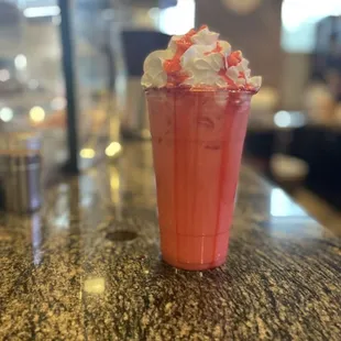 a pink drink with whipped cream on top