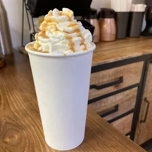 a cup of coffee with whipped cream and caramel