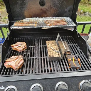 Someone elses grill that i am cooking smoked chops, smoked bacon up top. Crown Royal cask chunks (on fire) and sweet wood blend in the box.