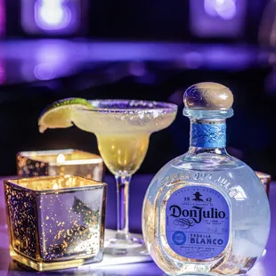 a bottle of tequila and a glass of margarita