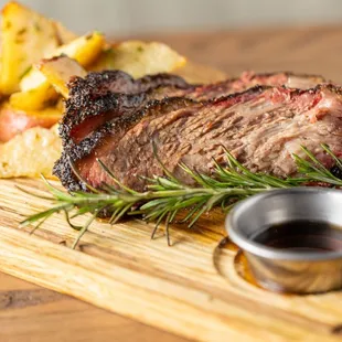 a steak and potatoes on a cutting board