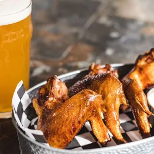 a basket of wings and a glass of beer