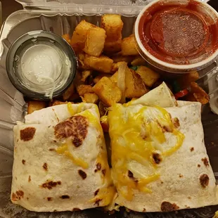 Closeup of my breakfast burrito with bacon inside. Also includes fried potatoes and salsa and sour cream. YUM!