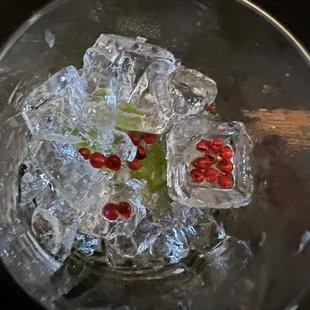 a glass filled with ice and pomegranates