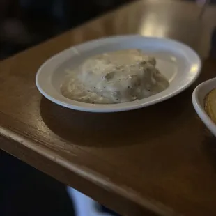 a plate of mashed potatoes and a bowl of gravy