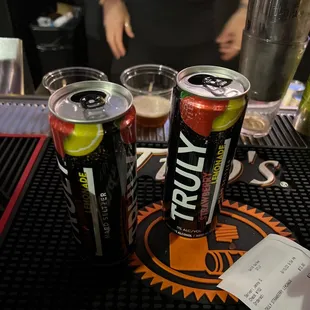 two cans of beer on a bar