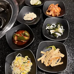Kimchi, Fish cakes, Seaweed salad, Sprouts, Pickled cucumbers, mashed potatoes, spicy peppers in chilly sauce.