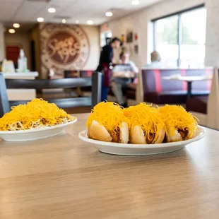 two plates of hot dogs on a table