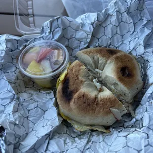 Fried egg and turkey on plain bagel, side of fruit