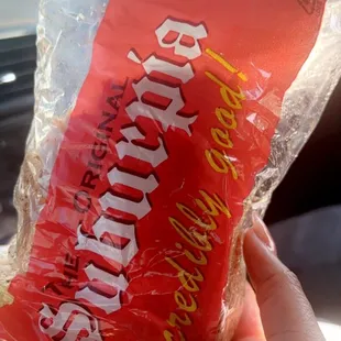 a hand holding a bag of chips