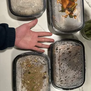 a person&apos;s hand reaching for a container of food