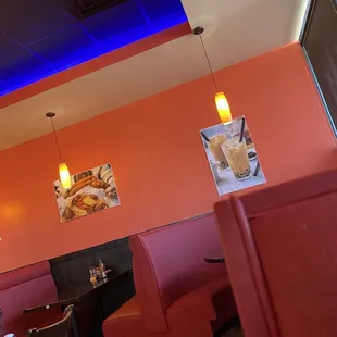 a restaurant with red booths and blue lights