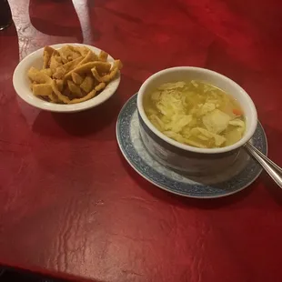 a bowl of soup and a plate of chips