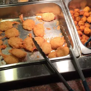 several trays of food in a buffet