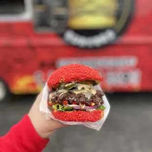 a hand holding a hamburger