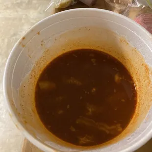Half full container of menudo.
