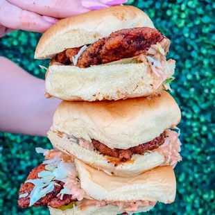 a hand holding a stack of sandwiches