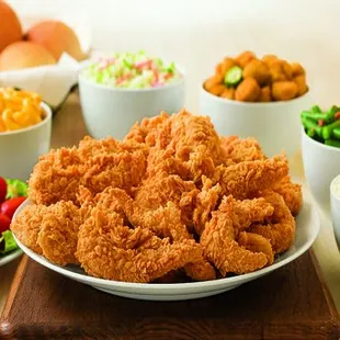 a plate of fried chicken and bowls of salads