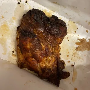 a burnt piece of chicken in a box