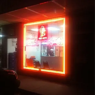 a neon sign in the window of a restaurant