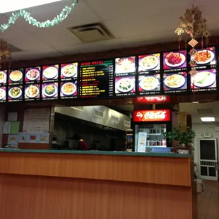 a restaurant counter with menus on the wall
