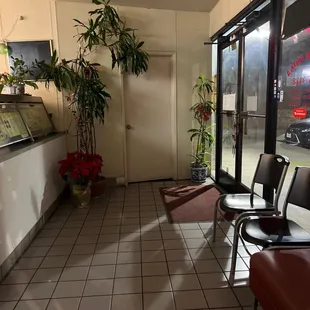 an empty waiting area with chairs and plants