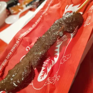 a stick of food on a red bag