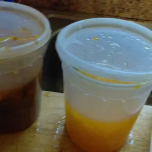 two plastic cups of iced coffee on a cutting board