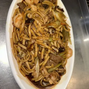 a plate of noodles with meat and vegetables