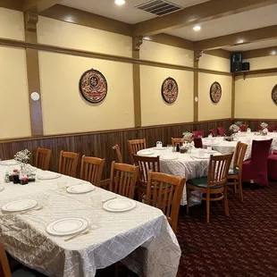 tables with white tablecloths and red chairs
