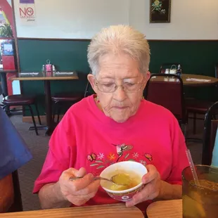 a woman eating a bowl of soup