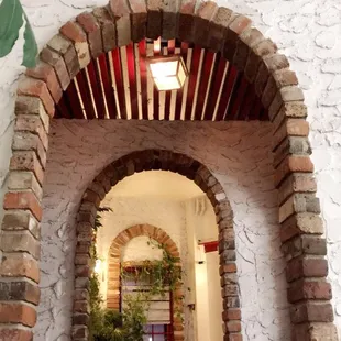 a brick archway with a plant in a pot