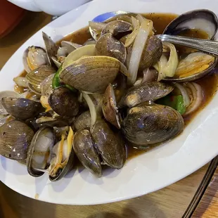 a plate of steamed clams on a table