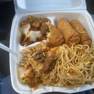 a styrofoam take out container with noodles, meat, and vegetables