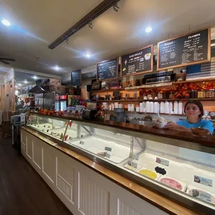 a woman behind a counter in a bakery