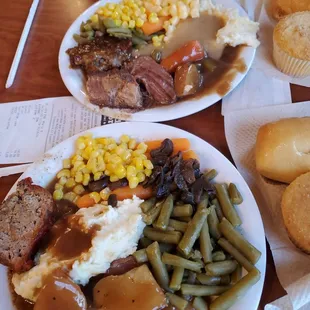 Variety of pot roast mashed potatoes green beans corn meatloaf