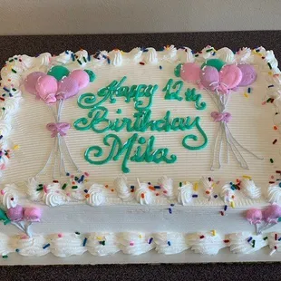 a birthday cake with balloons and confetti