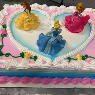 a heart shaped cake decorated with princesses