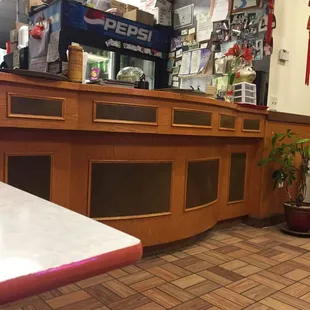 a restaurant counter with a red and white sign
