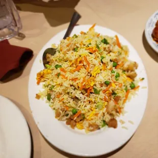 a plate of fried rice with carrots and peas