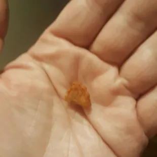 a tiny piece of food in the palm of a person