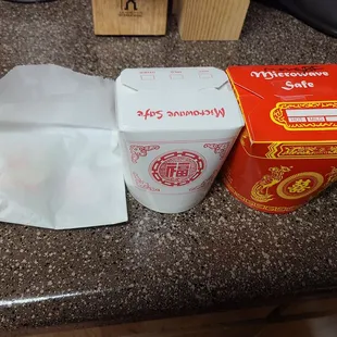 Take out. Paper bag with fortune cookie and sauce, white box with white rice, red box has the entree.