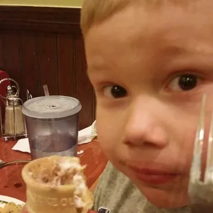 a young boy eating an ice cream cone