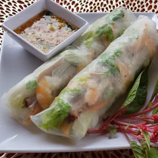 a plate of spring rolls with dipping sauce