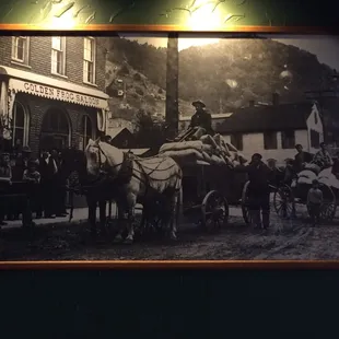 a horse drawn carriage in front of a black and white photo