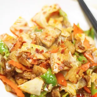 a plate of stir fried vegetables with chopsticks