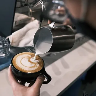 a person pouring milk into a cup